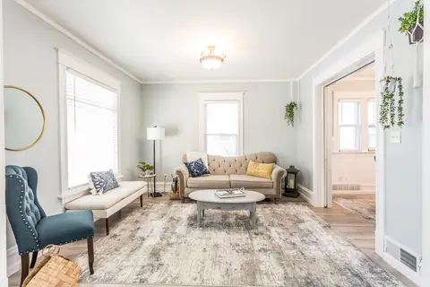 Living room with a tufted sofa, a blue armchair, and a round coffee table