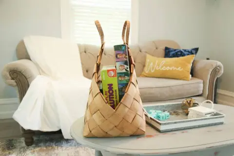 Basket of games and snacks in front of the living room sofa