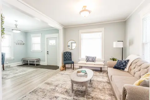 Living room and front entry with a sofa, armchairs, and an entry bench