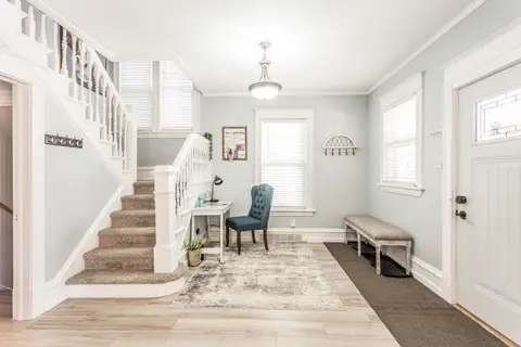 Staircase beside a small desk and chair near the front door