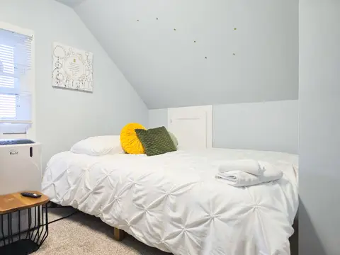 Attic bedroom with a queen bed under a sloped ceiling with star decals