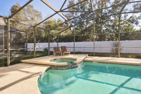 Hot tub at the edge of the pool, with loungers behind