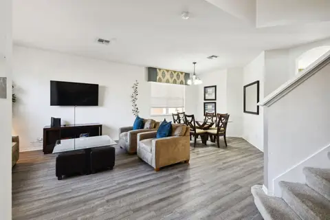Family room with a wall-mounted TV, open to the dining area