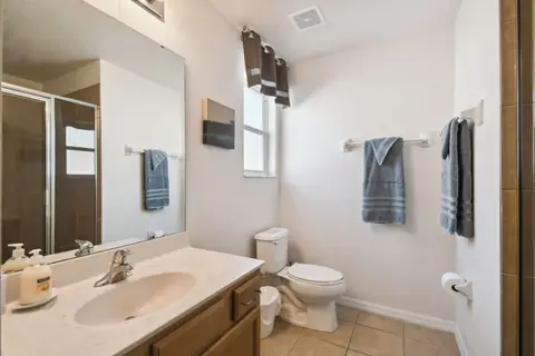 Bathroom with a glass shower, a vanity, and blue towels