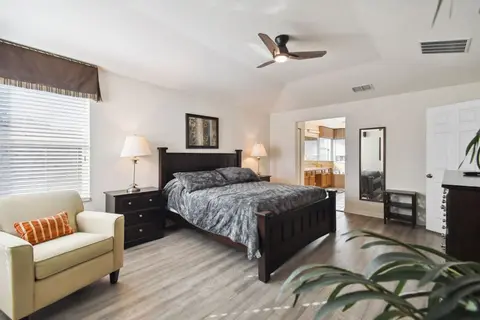 Primary suite with an armchair beside the bed
