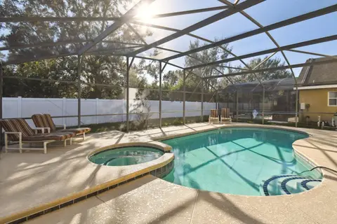 Pool and hot tub with sun loungers on the deck