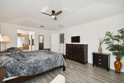 Queen bed facing a dresser with a TV