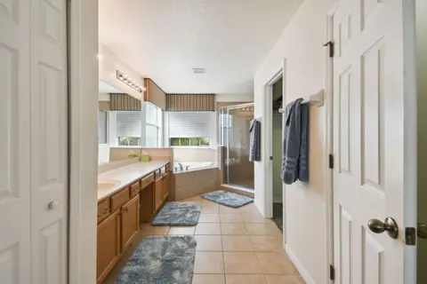 Primary bathroom with a long vanity and a soaking tub