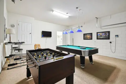 Game room with a pool table, foosball, and a bar seating area