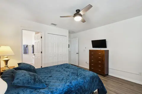 Queen bedroom with a dresser and a wall-mounted TV