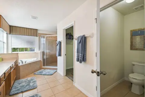 Primary bathroom with a corner tub and a separate toilet room