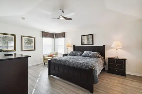 Primary suite with a queen bed, dressers, and a ceiling fan