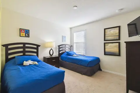 Twin bedroom with blue bedding and framed art