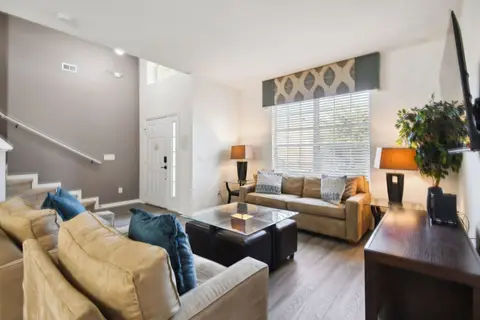 Living room with two sofas, table lamps, and a large front window
