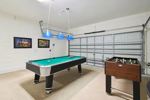 Game room with a pool table, foosball, and a wall-mounted TV