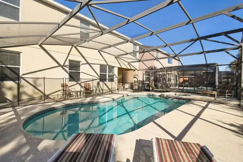 Pool deck with loungers under the screened enclosure