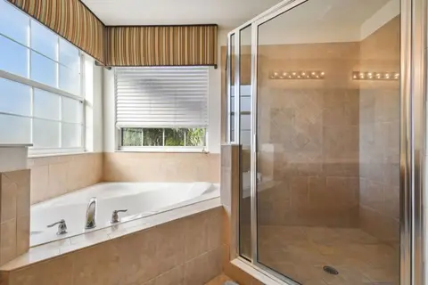 Corner soaking tub beside a glass walk-in shower