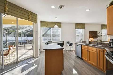 Bright kitchen with island seating and poolside views
