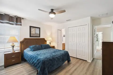 Queen bed with blue bedding beside a double closet