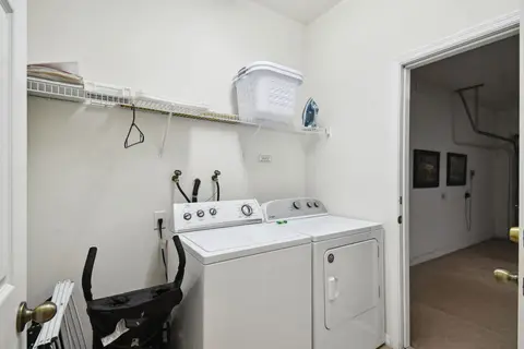 Laundry room with a washer, a dryer, and shelving