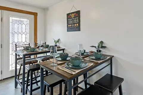 Two dining tables set with teal dishware beside a leaded glass door
