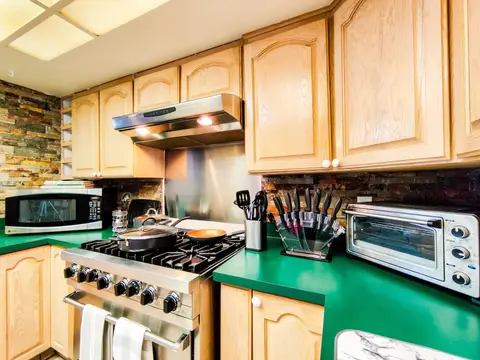 Viking gas range with a stainless hood, a toaster oven, and a microwave