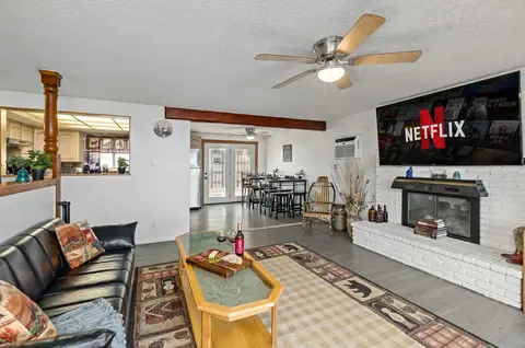 Upstairs living room with a glass-top coffee table and French doors to the yard
