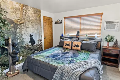 King bedroom with a black bear forest mural and bear bedding
