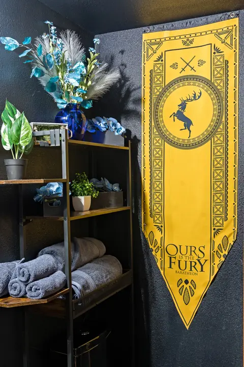 Bathroom shelves with towels and a yellow house banner
