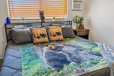 Carved bear on the headboard shelf above bear-print bedding