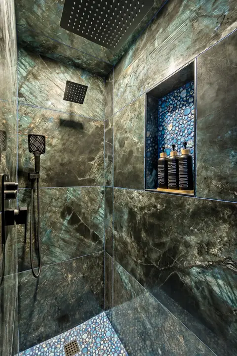 Tiled walk-in shower with a rain head and a pebble floor