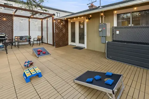 Deck with cornhole boards, a tic-tac-toe game, and patio seating