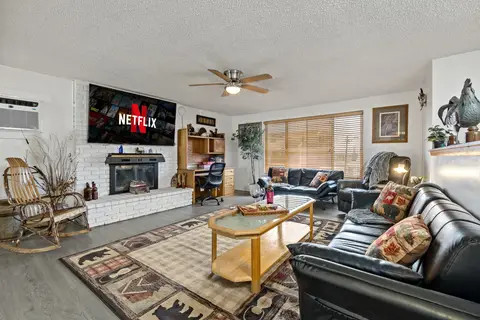 Upstairs living room with leather sofas, a rocking chair, a fireplace, and a wall-mounted TV