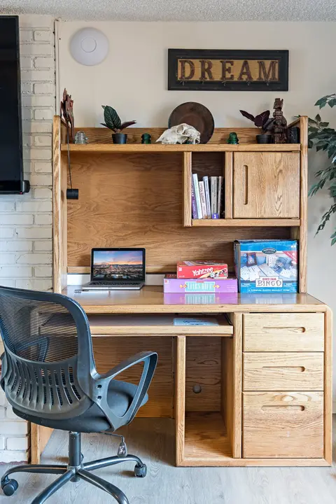 Oak desk with a hutch, an office chair, and board games
