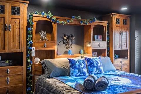 King bed with dragon bedding inside a carved oak wall unit
