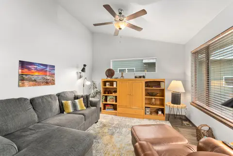 Living room with a gray sectional, yellow pillows, and a wood hutch