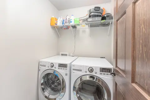 Front-load washer and dryer with a shelf of laundry supplies
