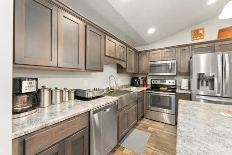 Kitchen counter with the sink, a dishwasher, and a coffee maker
