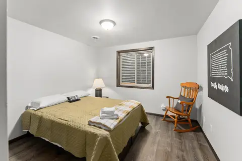 Bedroom with an olive bedspread, a rocking chair, and South Dakota wall art