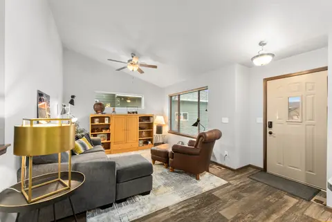 Living room with a gray sectional, a gold side table, and the front door