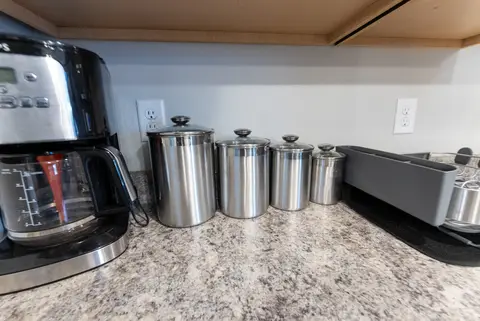 Coffee maker, canisters, and a toaster on the kitchen counter