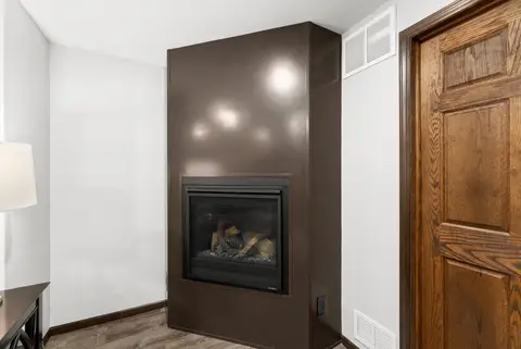 Fireplace set into a dark surround beside a wood door