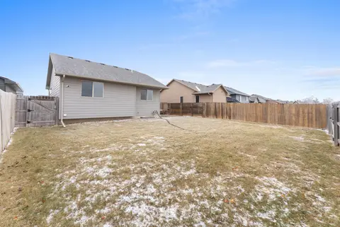 Backyard lawn and wood privacy fence behind the house