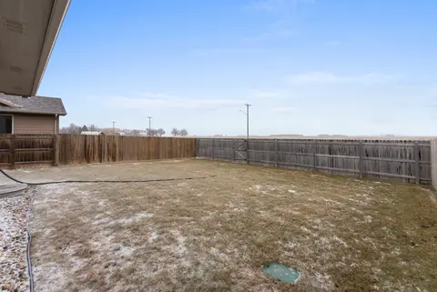 Fenced backyard with open sky beyond the fence