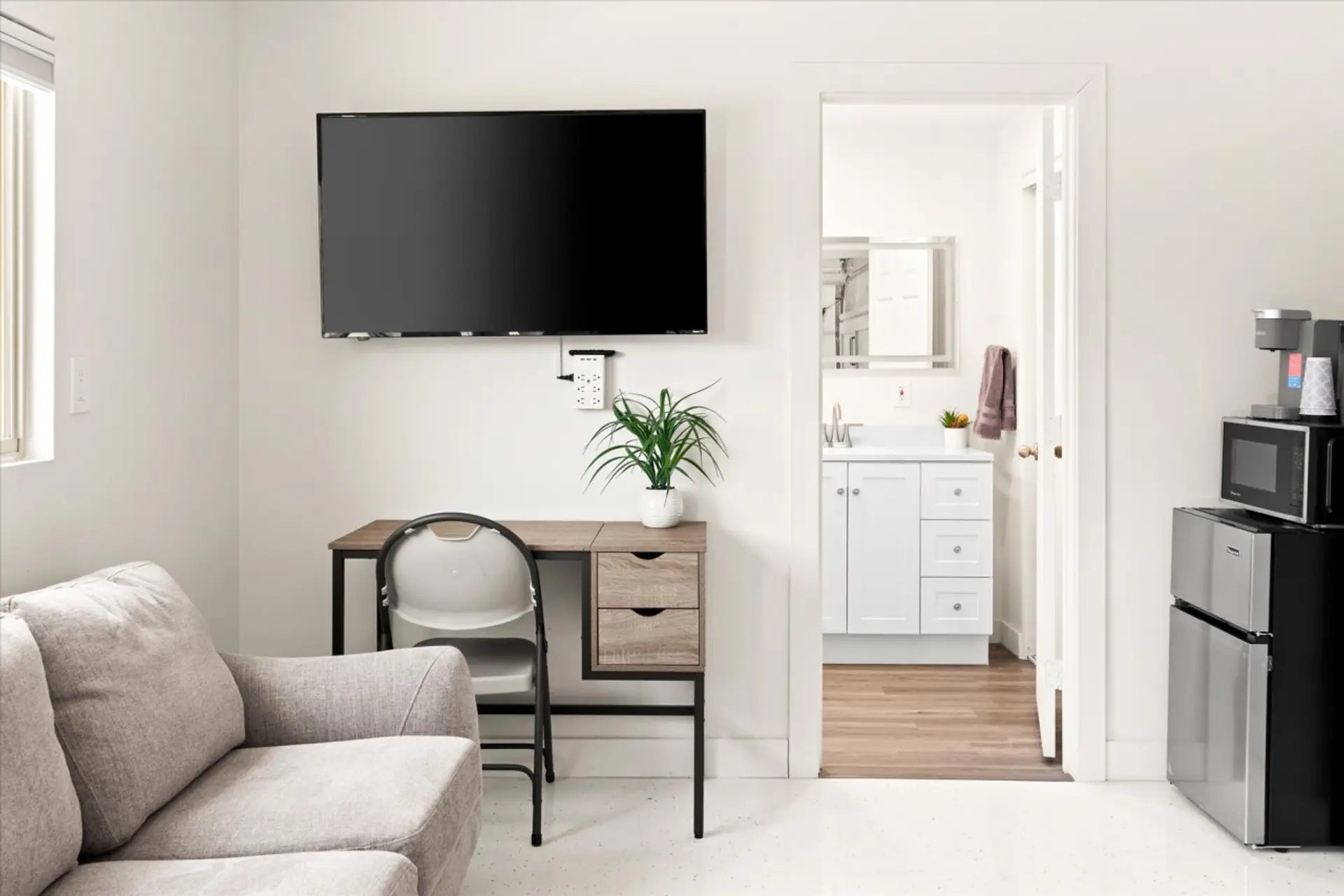 Bright and modern living space with a mounted TV and work desk.