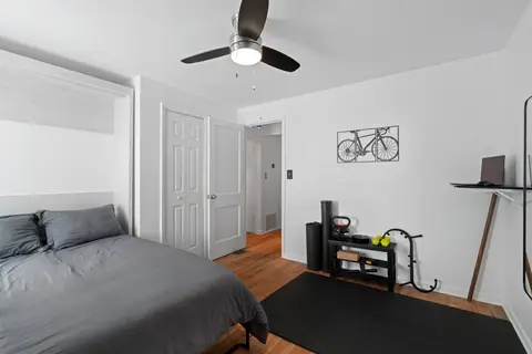 Queen bedroom with a workout corner, kettlebells, and a wall-mounted desk