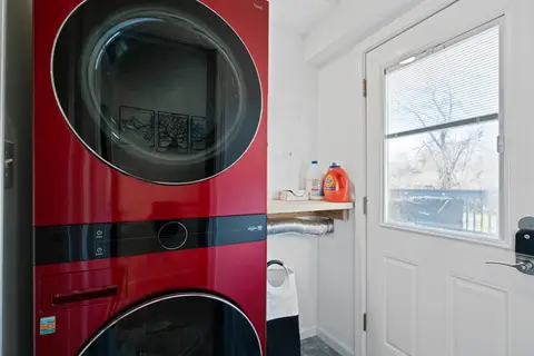 Red stacked washer and dryer beside the back door