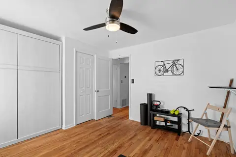 Bedroom workout corner with kettlebells and a mat, beside a wide closet