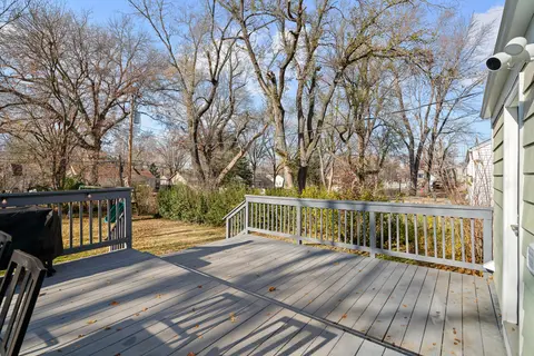 Back deck with a white railing, looking out to the trees
