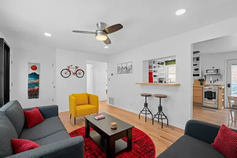 Living room open to the kitchen, with a pass-through counter and bar stools